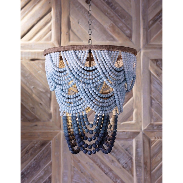 Blue wood beaded chandelier in front of a wood wall